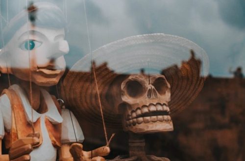 pinocchio dans une vitrine avec une tête de mort à côté